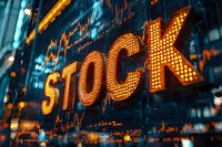 Illuminated STOCK text display with glowing orange marquee letters against digital market data background showing financial charts and numbers.