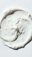 Creamy white whipped texture with swirled peaks and valleys, isolated on light background, suitable for cosmetics, skincare, dairy, and design applications.