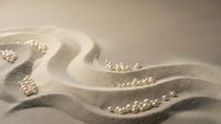 Soft beige sand dunes with delicate ripple patterns and gentle shadows creating natural texture for spa, wellness, meditation and relaxation concepts.