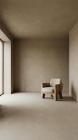 Minimalist interior space featuring a single upholstered armchair with wooden frame in neutral tones, positioned in empty room with concrete walls and natural light from window.