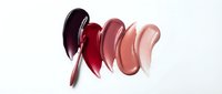 Lipstick swatches in burgundy red pink nude shades smeared on white background for cosmetic beauty makeup product advertising.