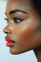 Close-up portrait of young African American woman with flawless skin wearing bold red lipstick and natural makeup for beauty and cosmetics campaigns.