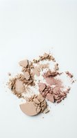 Crushed nude beige makeup powder scattered on white background. Broken cosmetic foundation creating textured beauty product display for skincare branding.