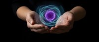 Hands holding glowing purple energy orb with blue light effects on dark background for spiritual healing and meditation concepts.