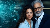 Diverse business team of mature bearded executive and young Hispanic female colleague against digital network background showing technology innovation.