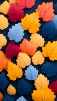 Colorful autumn paper leaves in orange, yellow, red and blue arranged on dark background, creating seasonal decorative pattern for fall designs and crafts.