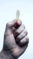 Close-up of male hand holding small oval jade stone against white background. Isolated on white for design use, suitable for wellness, spirituality, and alternative medicine concepts.