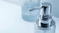 Modern chrome soap dispenser with clear container on white surface for bathroom and kitchen hygiene applications.