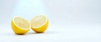 Fresh lemon halves cut in half showing juicy citrus flesh on clean white background for healthy cooking and natural vitamin C supplement concepts.