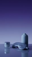 Skincare cosmetics set with sleep mask, cream jar, and bottle on reflective surface against gradient purple background for beauty product marketing.