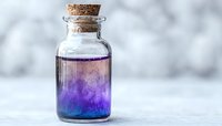 Small glass bottle with cork stopper containing purple and blue liquid against soft white background, suitable for wellness or spa concepts.