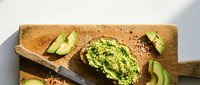 Fresh avocado toast with herbs on rustic wooden cutting board, healthy breakfast or snack concept for food blogs and restaurant menus.