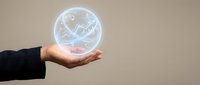 Global business growth and financial success concept with hand holding glowing globe displaying world map and rising stock market charts for investment and economy.