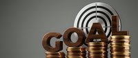 Bronze metallic GOAL letters on ascending coin stacks with target bullseye background representing financial success and achievement motivation.