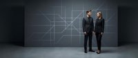 Professional business team standing in modern corporate environment with geometric digital network background for technology presentations.