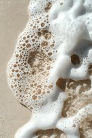 Ocean waves with white foam and bubbles washing over sandy beach shore creating natural coastal pattern for summer vacation and travel backgrounds.