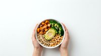 Overhead view of hands holding a nutritious bowl with roasted sweet potato, chickpeas, quinoa, avocado and leafy greens. Perfect for healthy eating, wellness and diet content.