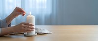 Woman hands holding white coffee mug at wooden desk with laptop in bright office workspace for morning productivity and remote work lifestyle.