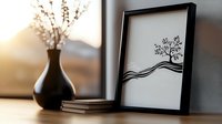 Minimalist black and white tree artwork in frame displayed on shelf with decorative vase and books creating modern home decor styling for interior design.
