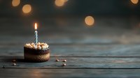 Small chocolate cupcake with single burning candle on rustic wooden table against dark background with bokeh lights, celebration concept.
