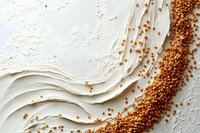 Creamy white textured waves with scattered golden quinoa grains creating dynamic diagonal composition on light background, macro food photography.