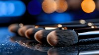 Professional makeup brushes with soft bristles on dark background with glitter and bokeh lights, beauty cosmetics tools for applying powder and foundation.