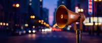 Vintage megaphone on city street at dusk with blurred traffic lights and urban bokeh background for announcements and communication campaigns.