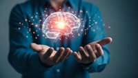 Businessman holding glowing brain hologram with neural network connections representing artificial intelligence and innovative technology solutions.