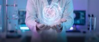 Healthcare professional displaying holographic heart symbol with digital interface technology in modern medical facility environment.
