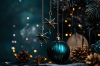 Festive composition with teal glass ball ornament, golden star decorations and pine cones against dark background with bokeh lights creating magical holiday mood.