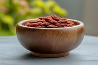 Fresh goji berries in wooden bowl on kitchen counter for healthy eating and superfood nutrition concepts.
