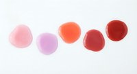 Colorful watercolor paint drops in pink purple orange and red tones on white background for artistic design projects and creative applications.