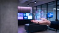 Modern office worker holding holographic digital network globe with data connections in futuristic workspace with multiple screens and purple lighting.