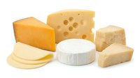 Assorted cheese varieties including cheddar, emmental, and fresh white cheese isolated on white background for food and dairy product design use.