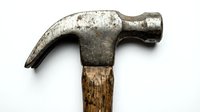 Worn claw hammer with weathered metal head and aged wooden handle isolated on white background for construction, repair, and DIY projects.
