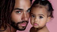 African American father with dreadlocks and young daughter sharing tender moment against soft pink background for family portrait photography.