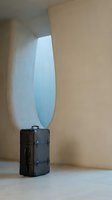 Modern minimalist interior with black leather suitcase in curved archway niche with soft natural lighting for travel and lifestyle concepts.