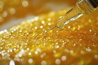 Macro shot of golden liquid drops falling from glass dropper with sparkling bokeh effect and glitter background, creating luxurious cosmetic atmosphere.