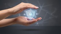 Hands protecting glowing cybersecurity shield with lock icon. Digital data protection and privacy concept for business technology solutions.
