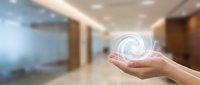 Hands holding a glowing swirling energy vortex in a modern office corridor, symbolizing innovation, technology, and future business concepts.