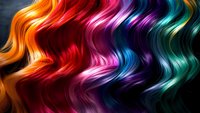 Vibrant wavy rainbow hair strands flowing in gradient colors from orange to red, pink, purple, and turquoise creating dynamic motion pattern on dark background.
