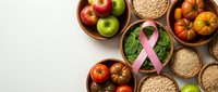 Healthy organic food arrangement with pink ribbon symbol for breast cancer awareness campaign featuring fresh fruits vegetables and whole grains on neutral background.