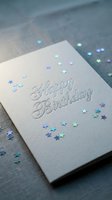 Happy Birthday greeting card with holographic star confetti on gray textured background, elegant embossed script lettering for celebration.