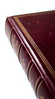 Burgundy leather-bound book with gold embossed spine and decorative gilt detailing, showcasing classic bookbinding craftsmanship and vintage literary aesthetics.