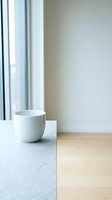 White ceramic cup on marble countertop near window with natural light, minimalist interior design for home decor, lifestyle, and modern living space concepts.