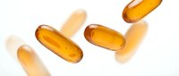 Golden omega-3 fish oil capsules floating on white background with soft shadows. Health supplement pills for wellness and nutrition support.