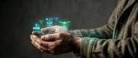 Senior man cupping hands holding glowing digital house hologram representing smart home technology and real estate investment concepts.