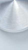 Brushed metal surface with radial circular pattern and reflective shine for modern industrial design backgrounds and technology applications.