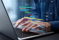 Business professional analyzing colorful data charts and graphs on laptop with holographic interface overlay for project management and analytics.