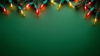 Colorful vintage Christmas lights with red and yellow bulbs on pine branches against dark green background, creating festive holiday border at top of frame.